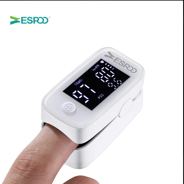 Fingertip pulse oximeter clipped on a finger showing SpO₂ and pulse rate on its LED display